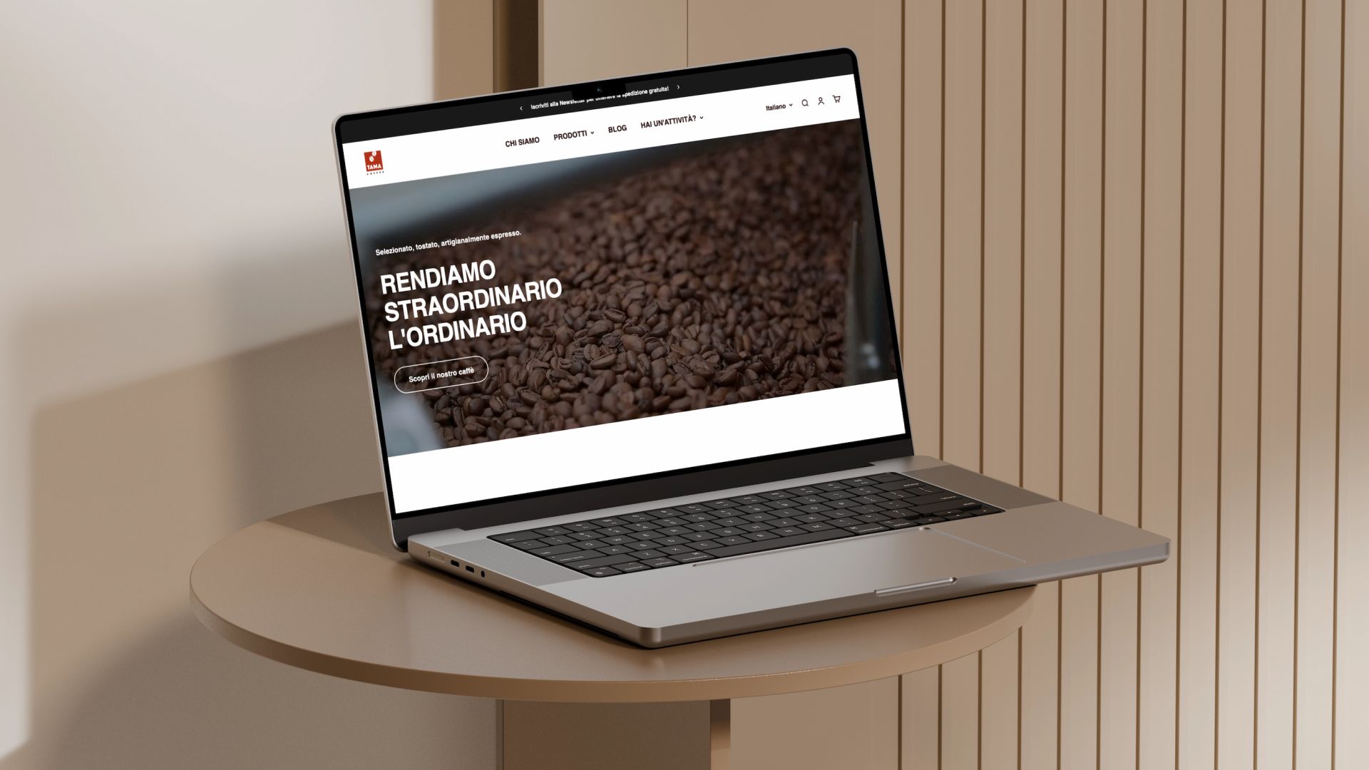 The TAMA caffè site open on a laptop, on a wooden table