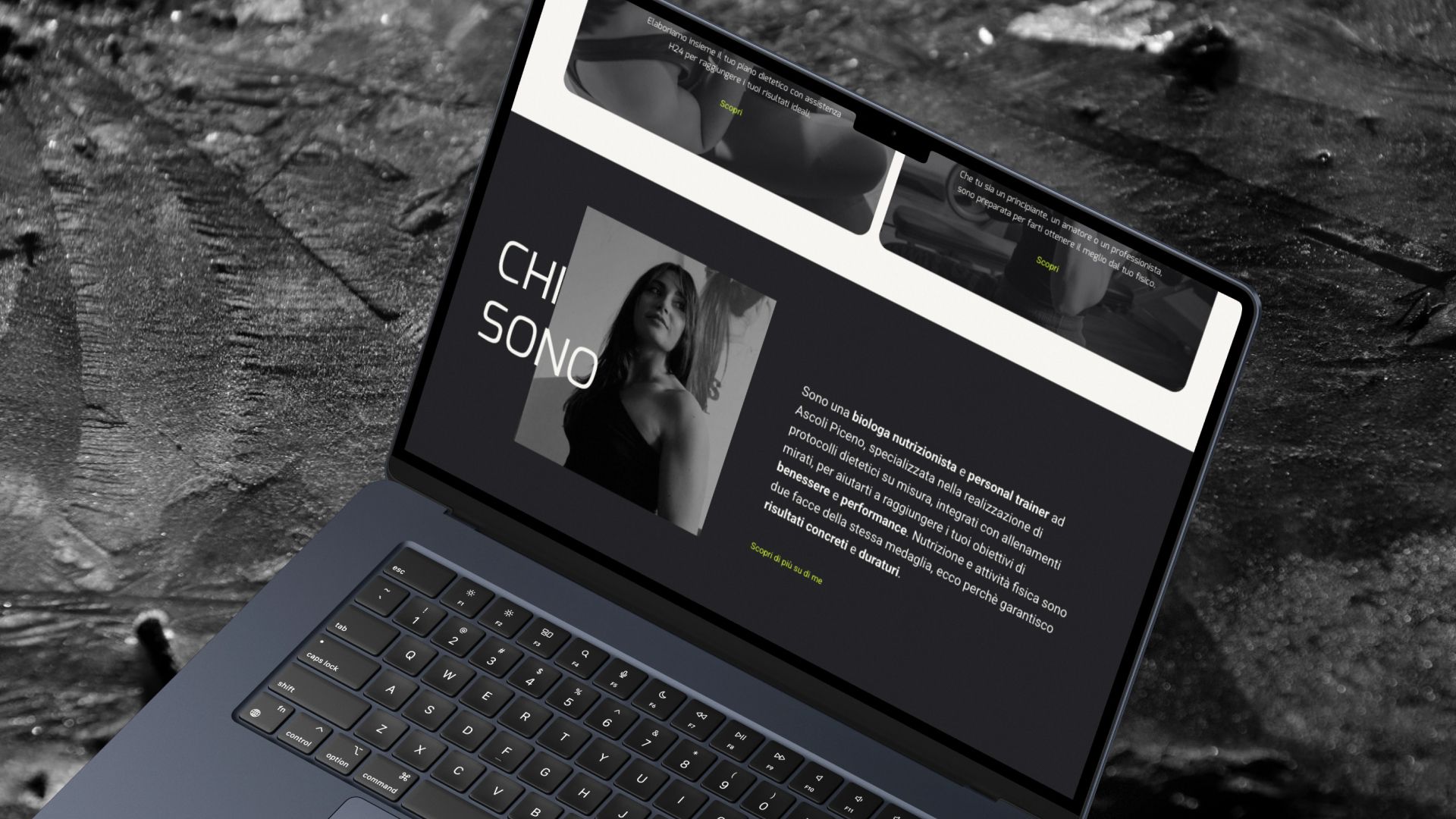 A laptop shows the “About” section, with the black and white portrait on a dark background